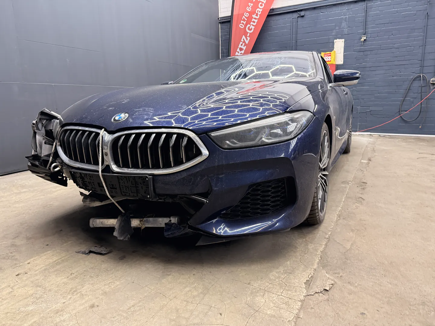 Originalfoto eines blauen BMW mit beschädigter Fahrzeugfront